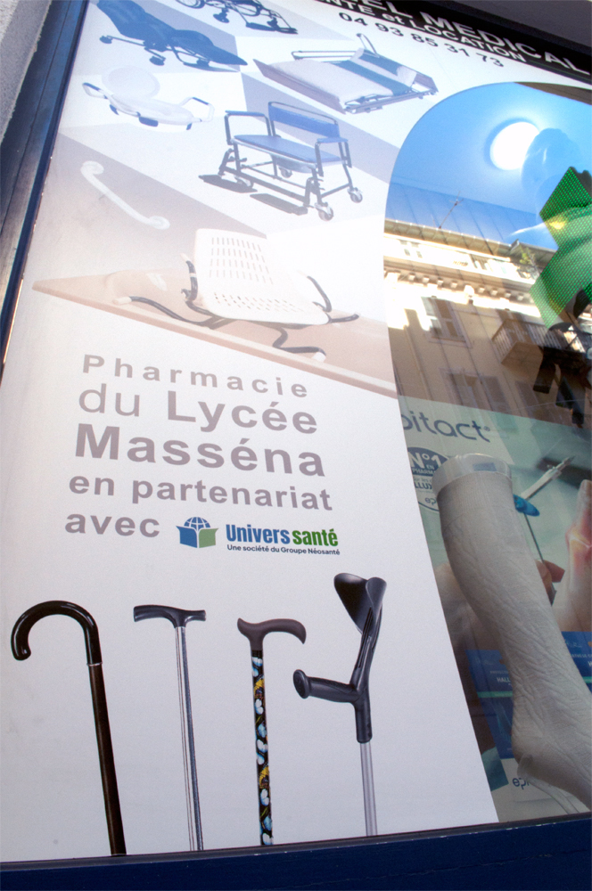 Détail de la vitrophanie de pharmacie avec découpe arrondie.