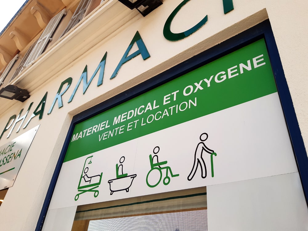 Icônes graphiques déclinées sur un affichage de rue d'une vitrine avec écran vidéo pour une pharmacie.